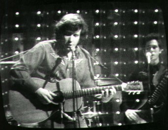 A screenshot of a Midnight Special television broadcast shot by Rob Stoner’s father, Arthur Rothstein, with Stoner standing behind Don McLean.